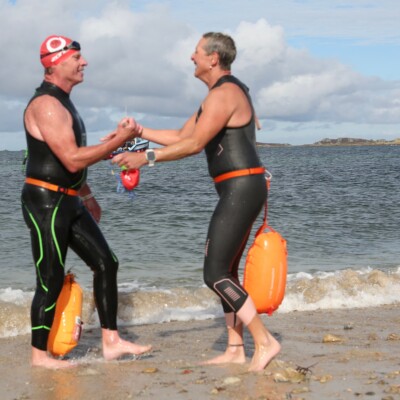Swimmers shake hands at the end of a swim in the Isles of Scilly