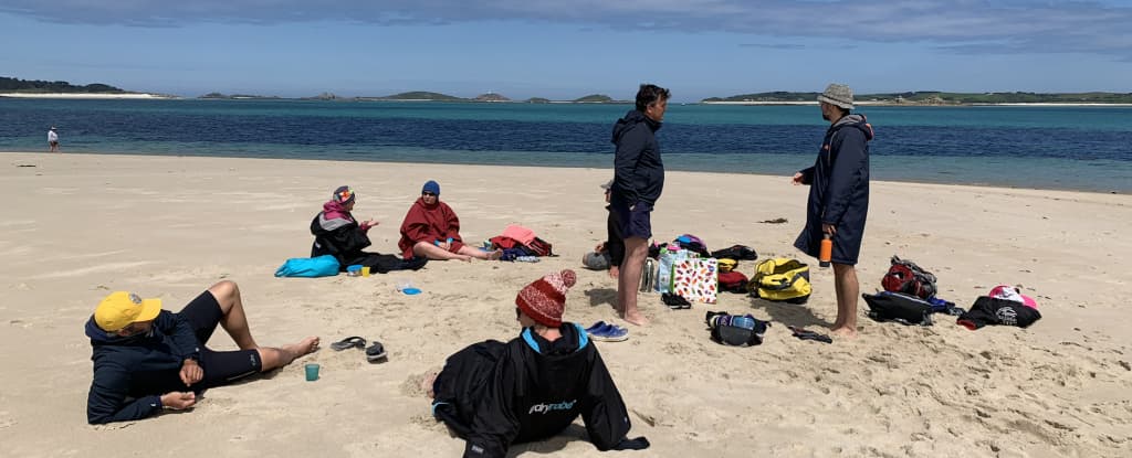 Swimmers relaxing on beach in the Scilly Isles