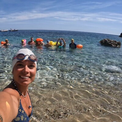 Swim guide stands in front of swimmers in Greece