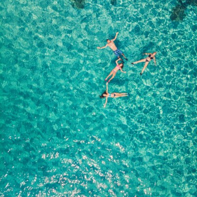 Group laying on their backs in the turquoise sea.