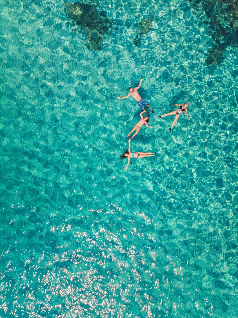 Group laying on their backs in the turquoise sea.