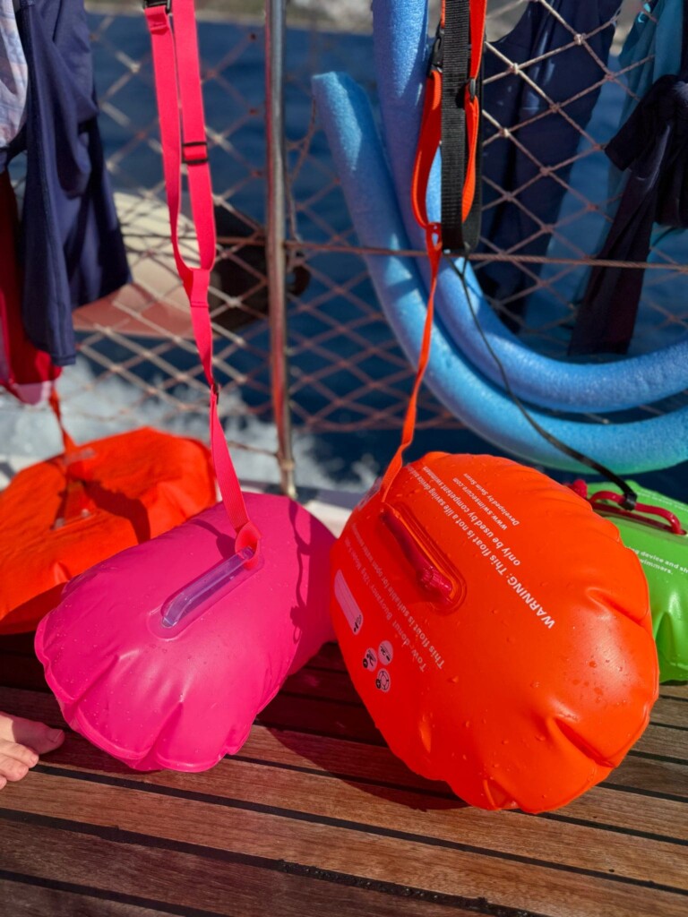 Orange and pink outdoor swimming floats on a ships deck