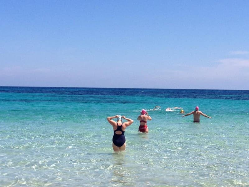 Swimmers entering blue sea in Formentera