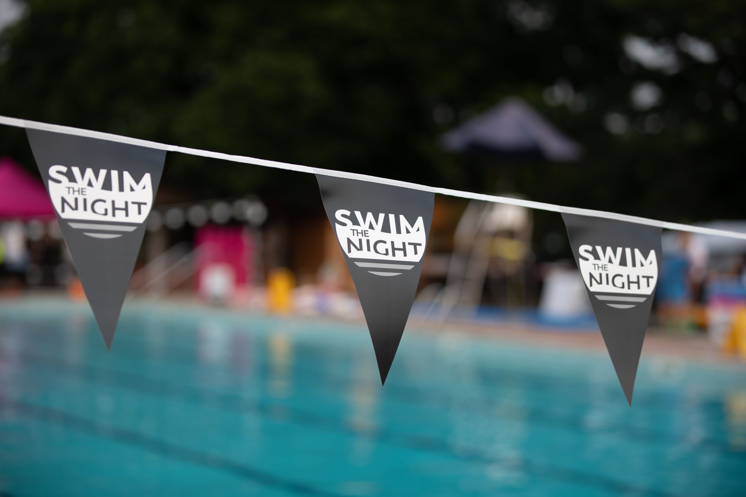 Swim the Night flags over pool